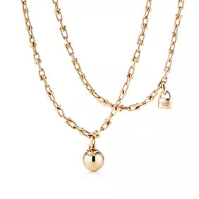 Tiffany gold wrap necklace—double-strand chain featuring signature spheres and a lock pendant.
