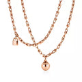 Tiffany gold wrap necklace—double-strand chain featuring signature spheres and a lock pendant.