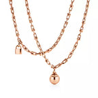 Tiffany gold wrap necklace—double-strand chain featuring signature spheres and a lock pendant.