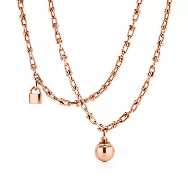 Tiffany gold wrap necklace—double-strand chain featuring signature spheres and a lock pendant.