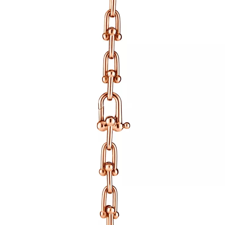 Tiffany gold wrap necklace—double-strand chain featuring signature spheres and a lock pendant.
